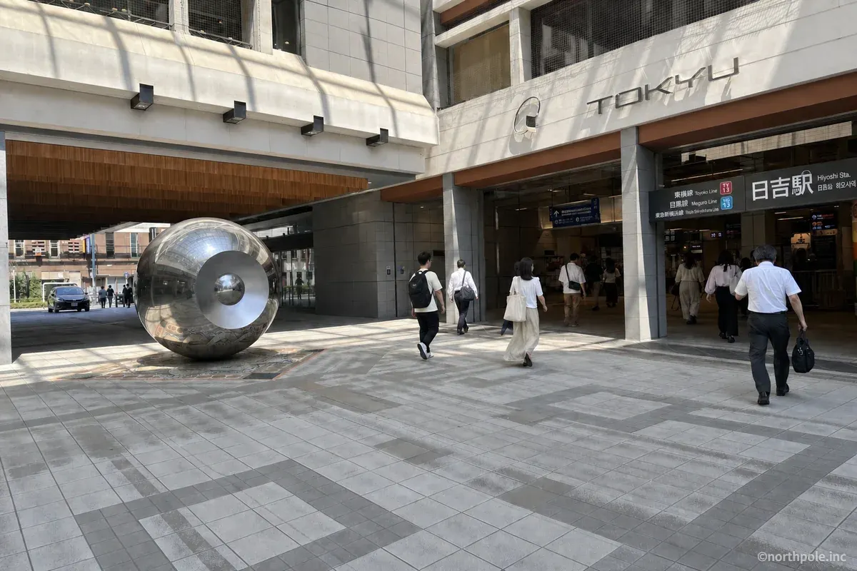 日吉駅前広場の銀色のモニュメントと駅舎
